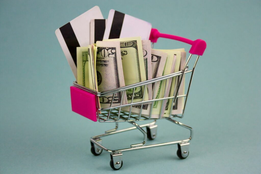 shopping cart with dollars and credit cards