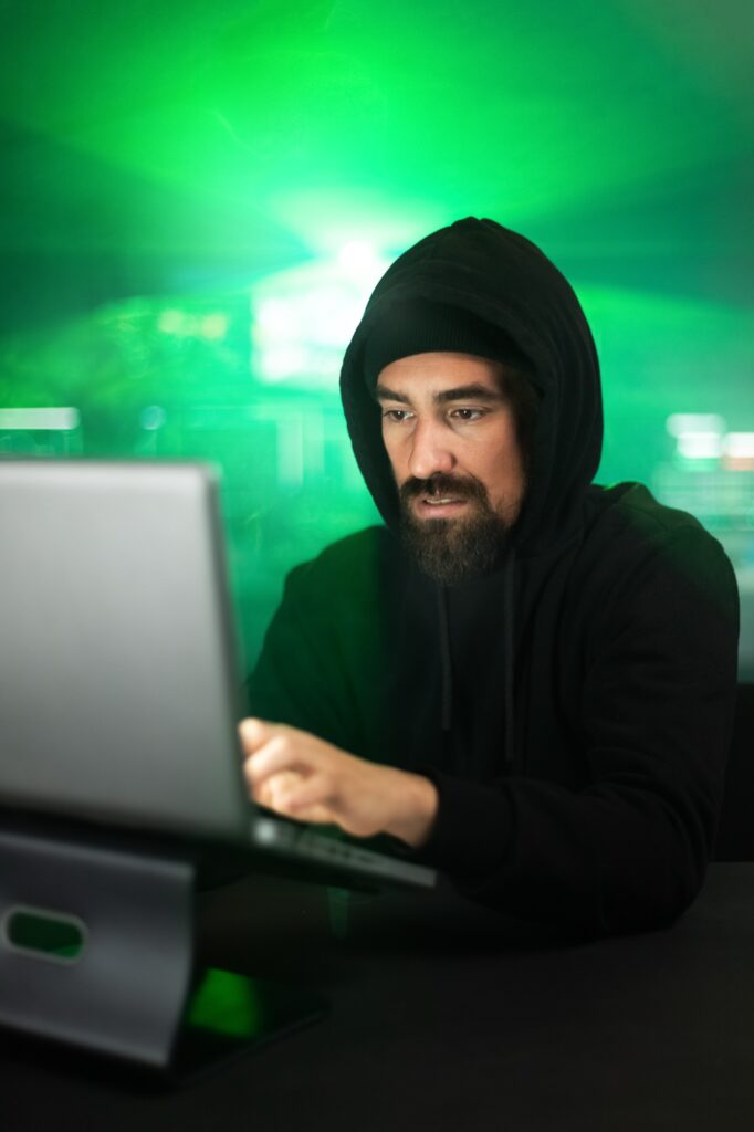Male black hat hacker hacking security firewall late in the office.Vertical image.